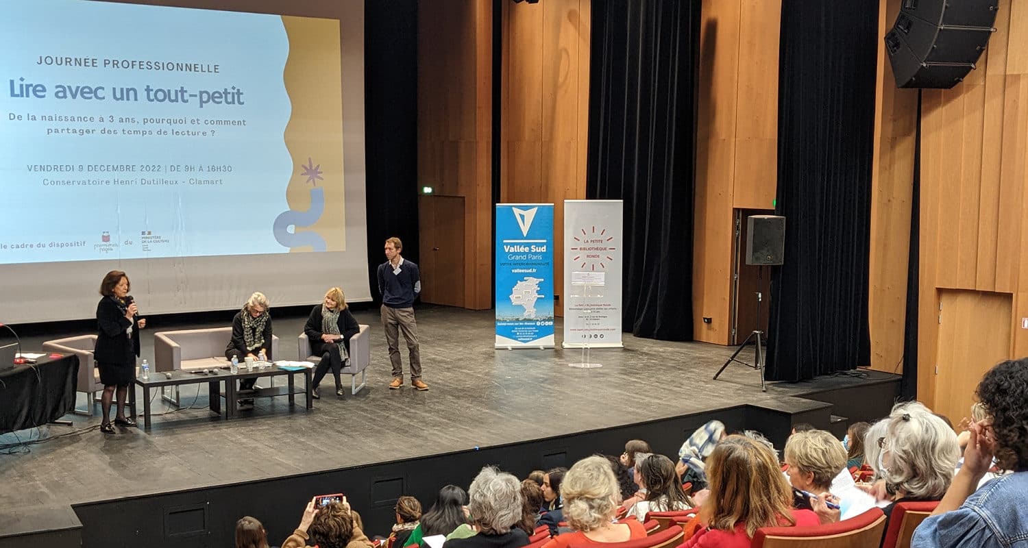 photo de la journée professionnelle "Lire avec un tout" petit, plusieurs personnes sur scène devant le public